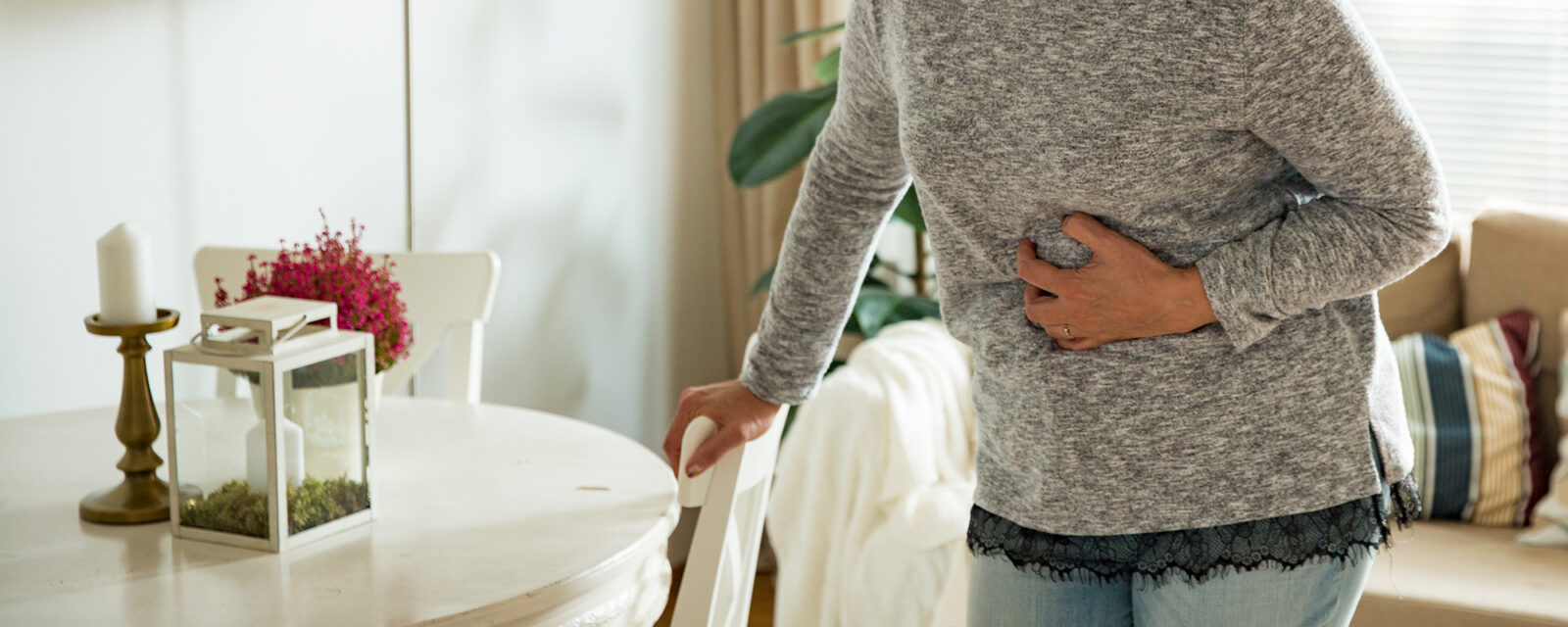 This is an image of a person grabbing their stomach due to pain from colon cancer.