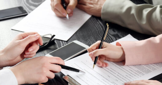 Hands of attorneys and client reviewing legal paperwork for mesothelioma compensation case