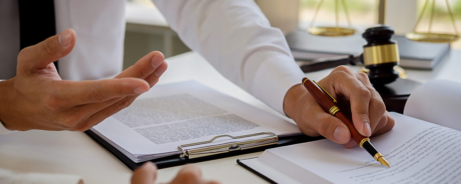 Close up image of a legal professional going over documents with a client.