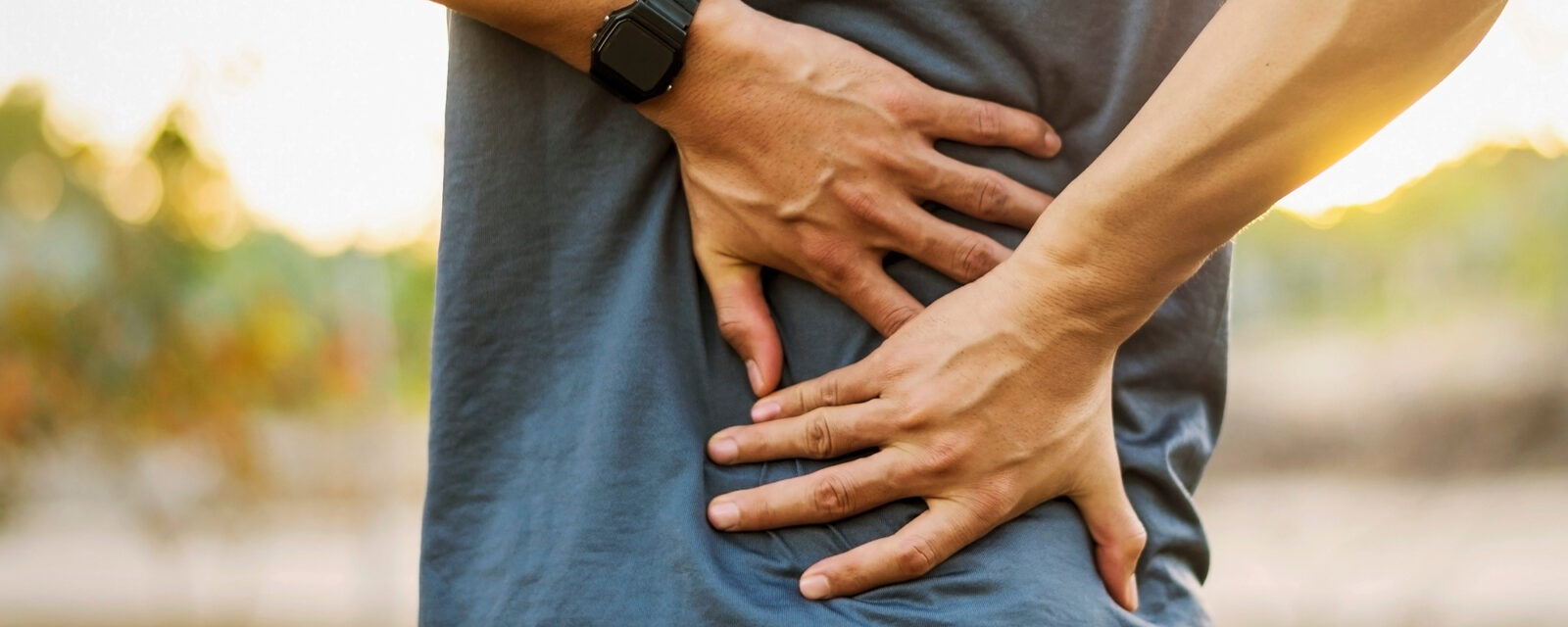 Image of a person grabbing their back.