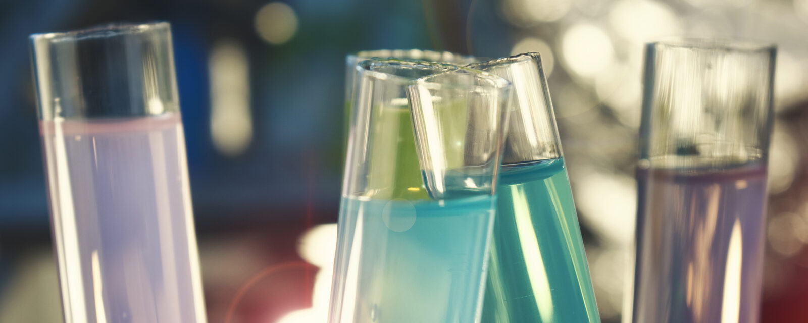 Image of four test tubes holding substances. Two are blue and two are purple.