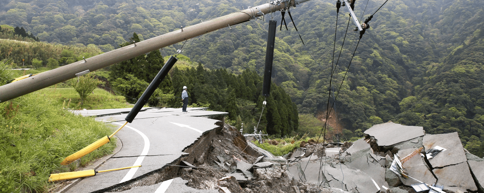 Image of earthquake side effects in the road - creating cracks, fallen electrical lines and damage.