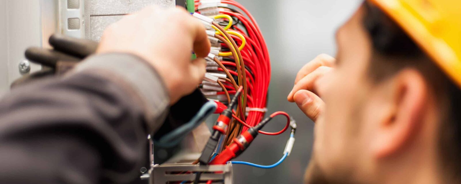 Electrician engineer tests electrical installations and wires on relay protection system. Bay control unit. Medium voltage switchgear.