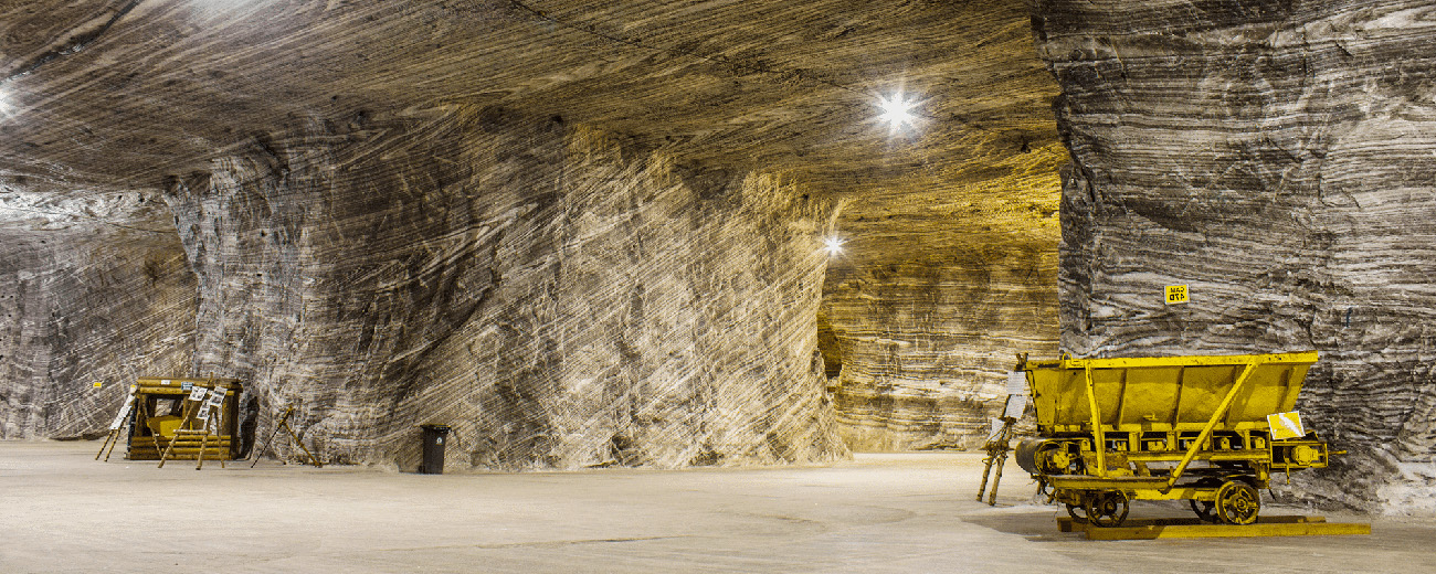 Image of a mining shaft that is well lit with yellow carts.