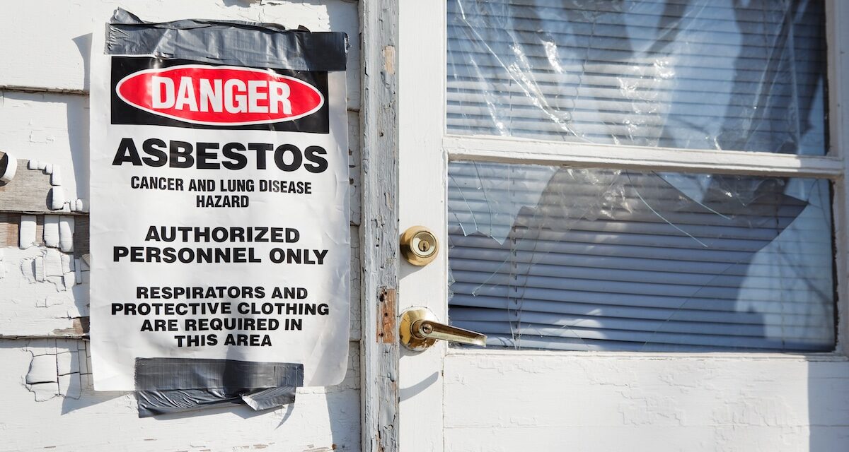 Danger Asbestos Sign near House Entry Door with chipped paint and broken window.