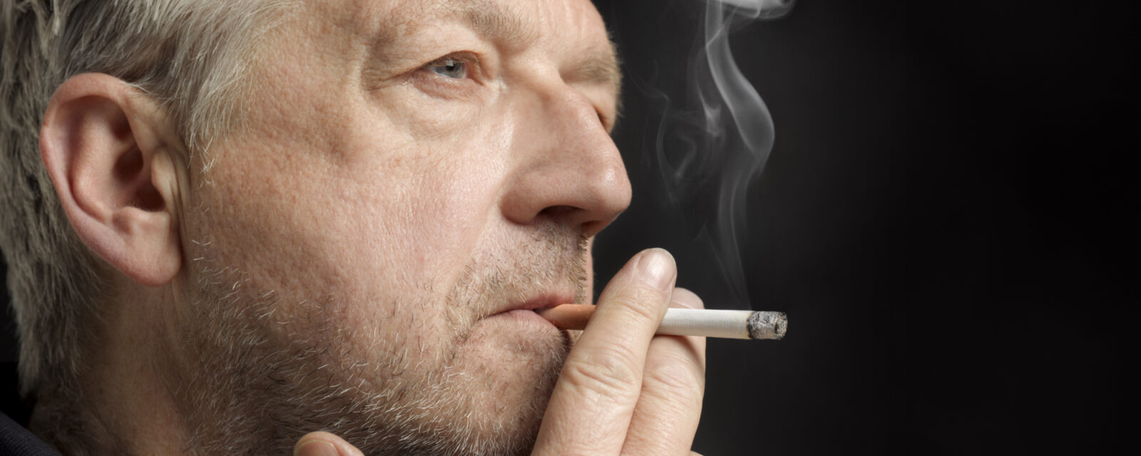 Close-up image of man smoking a cigarette.