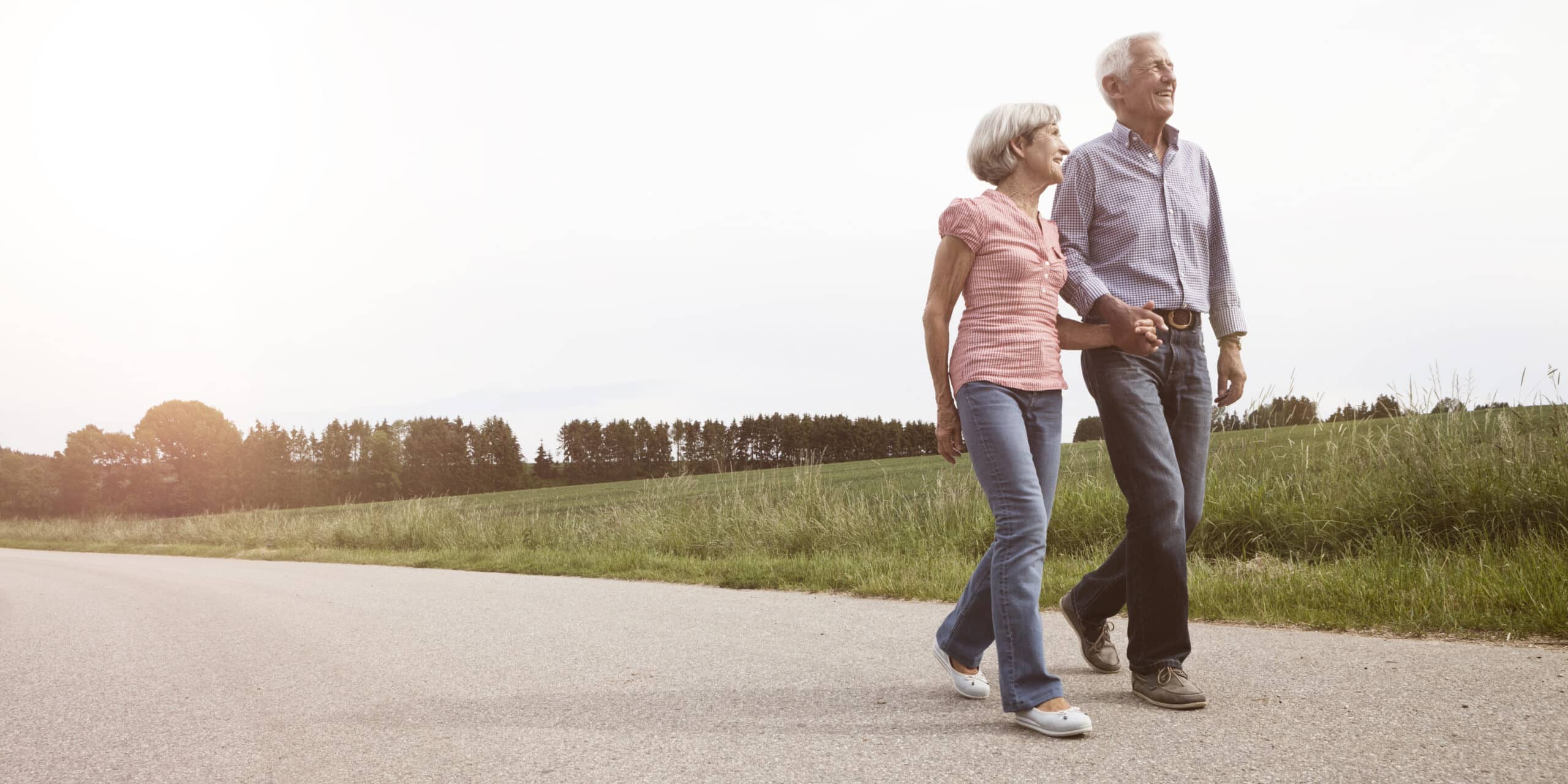Photo of older couple walking together outdoors.