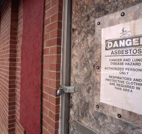 Sign stating, "Danger Asbestos," and "Cancer and lung disease hazard, authorized personnel only, respirators and protective clothing are required in this area."