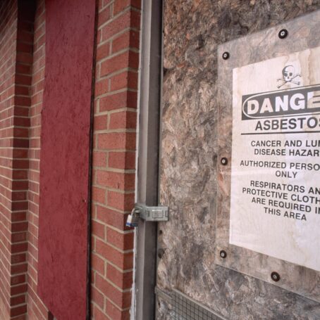 Sign stating, "Danger Asbestos," and "Cancer and lung disease hazard, authorized personnel only, respirators and protective clothing are required in this area."