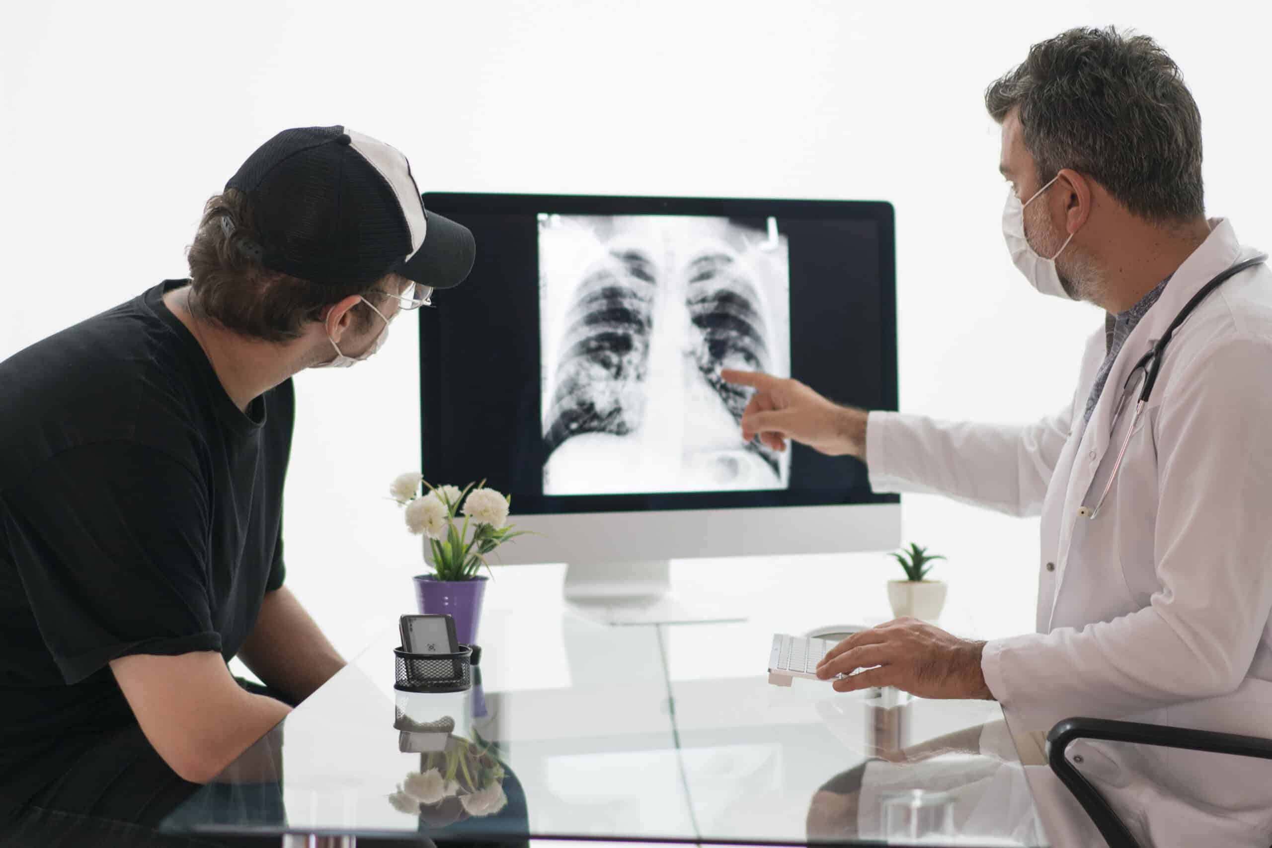 Doctor shows patient an x-ray and discusses the differences between mesothelioma and asbestosis.