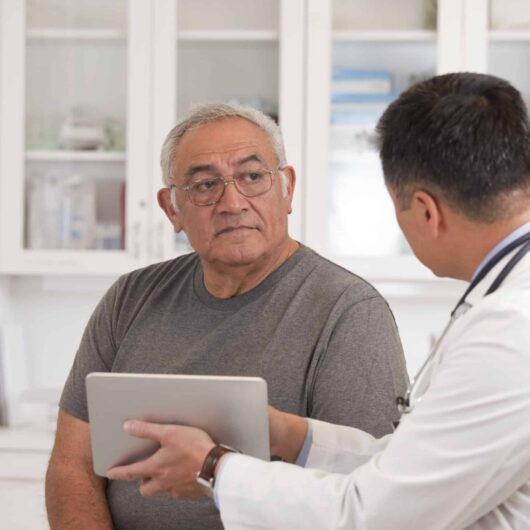 A doctor explaining a mesothelioma diagnosis, a fatal disease, to his patient.