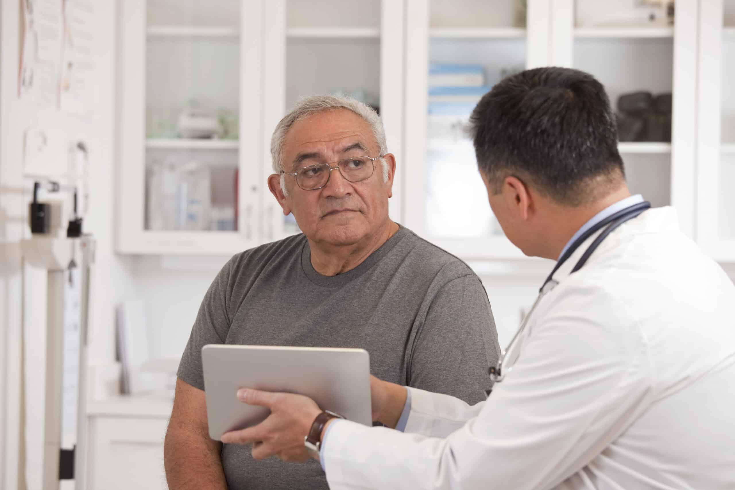 A doctor explaining a mesothelioma diagnosis, a fatal disease, to his patient.