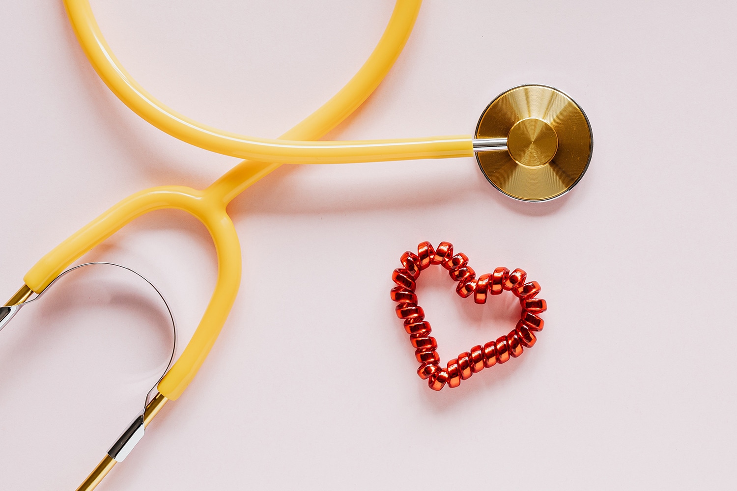 Picture of a yellow stethoscope next to a red cord to celebrate National Doctors Day.