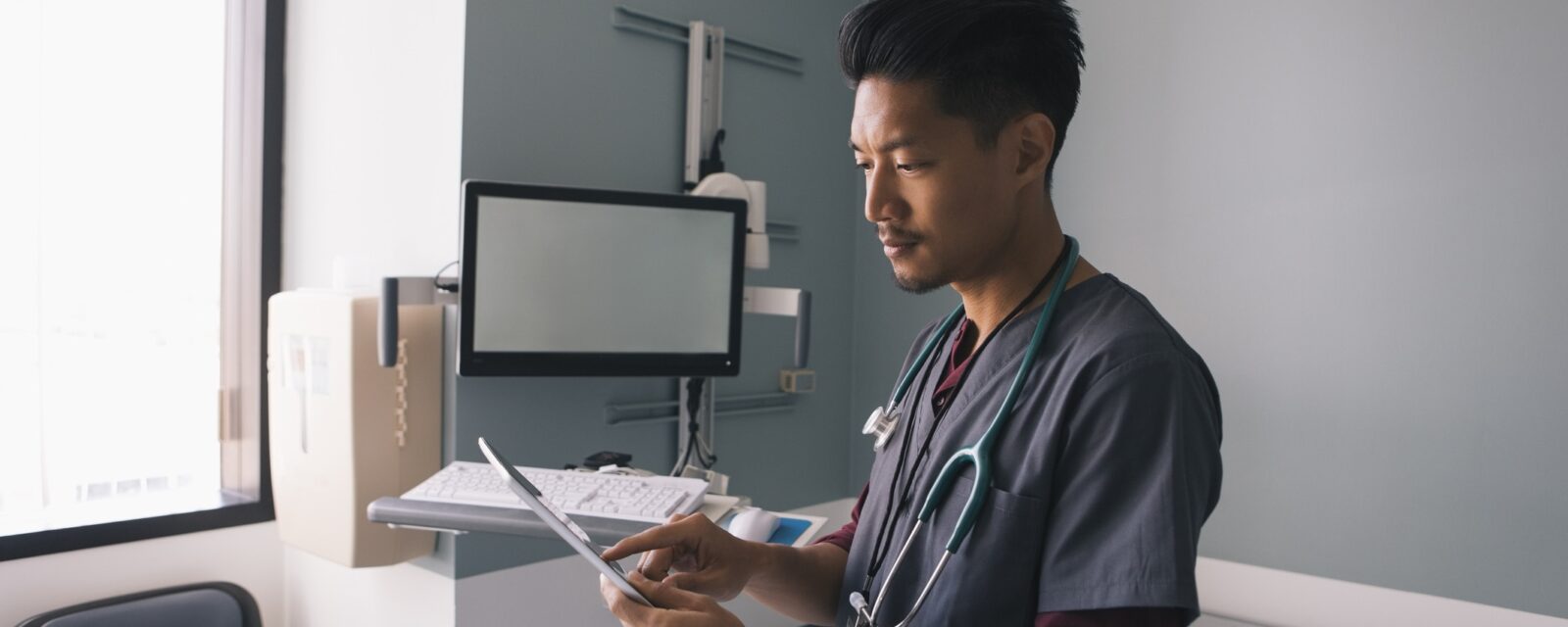Male nurse at Moffitt Cancer Center looking at test results on tablet.