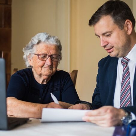 Mature woman and young man signing end of life documents.
