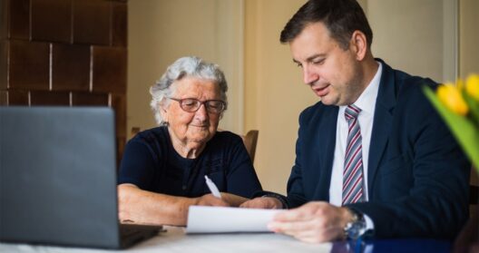 Mature woman and young man signing end of life documents.