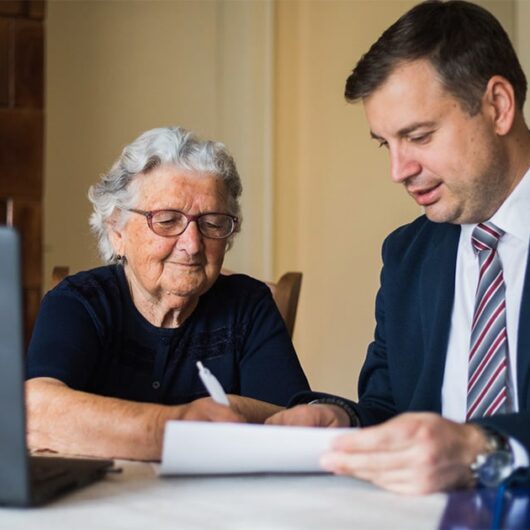 Mature woman and young man signing end of life documents.