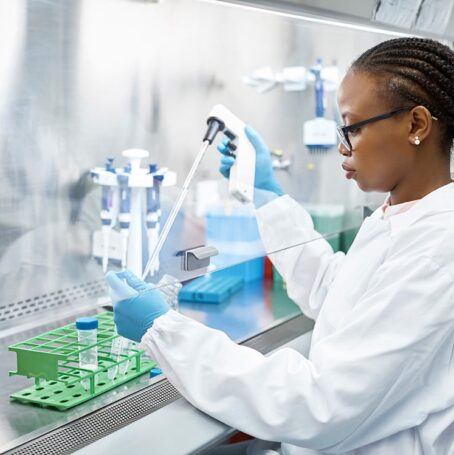 Female scientist analyzing medical sample in test tube. Young researcher is wearing lab coat.