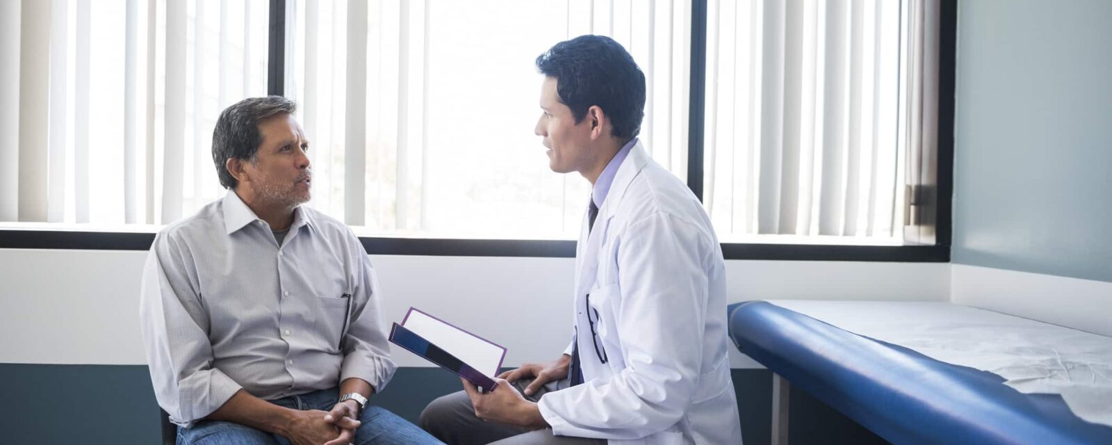 Male doctor talking with male patient.