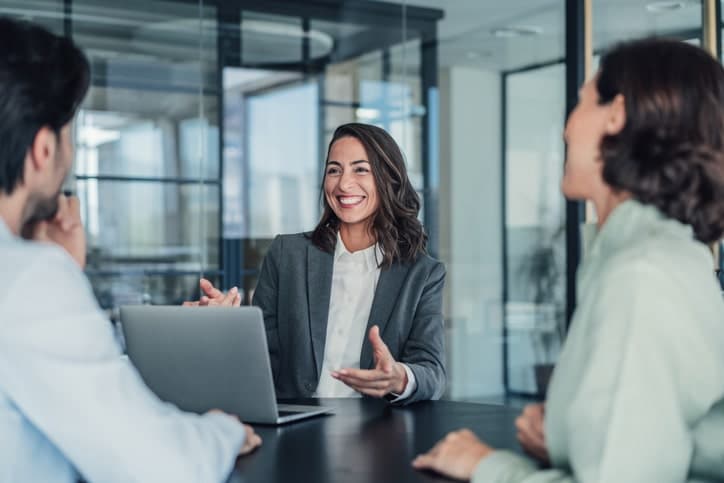 Female lawyer discussing case with male and female at mesothelioma law firm.