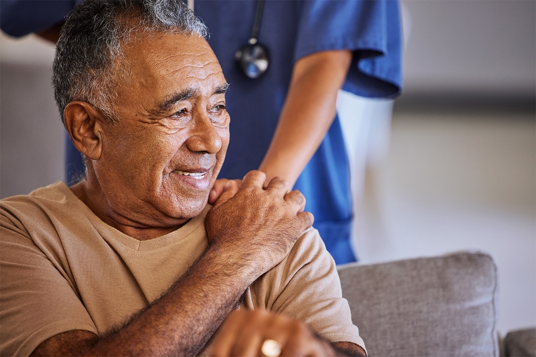 Nurse or doctor give man support during recovery or loss. Caregiver holding hand of her sad senior patient and showing kindness while doing a checkup at a retirement, old age home or hospital