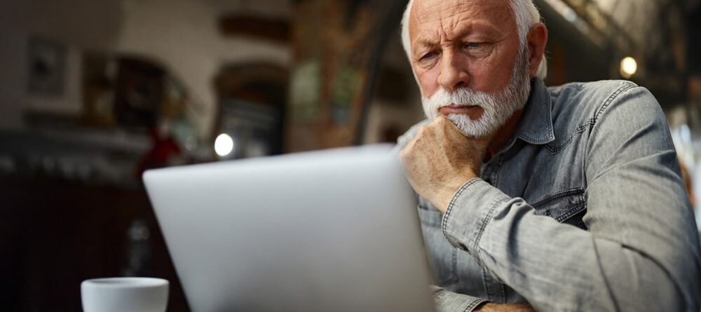Man researching mesothelioma patient education and advocacy information on laptop