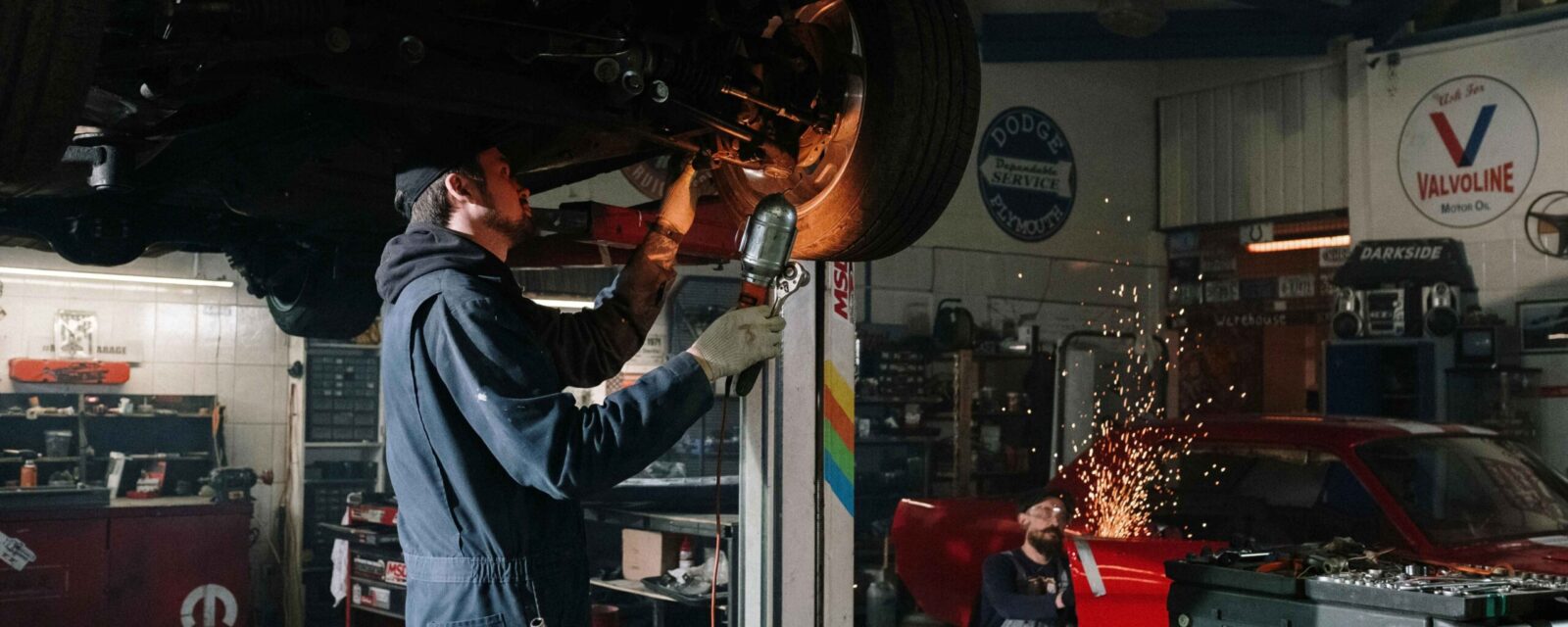 Mechanic working on car brakes in automotive repair shop garage