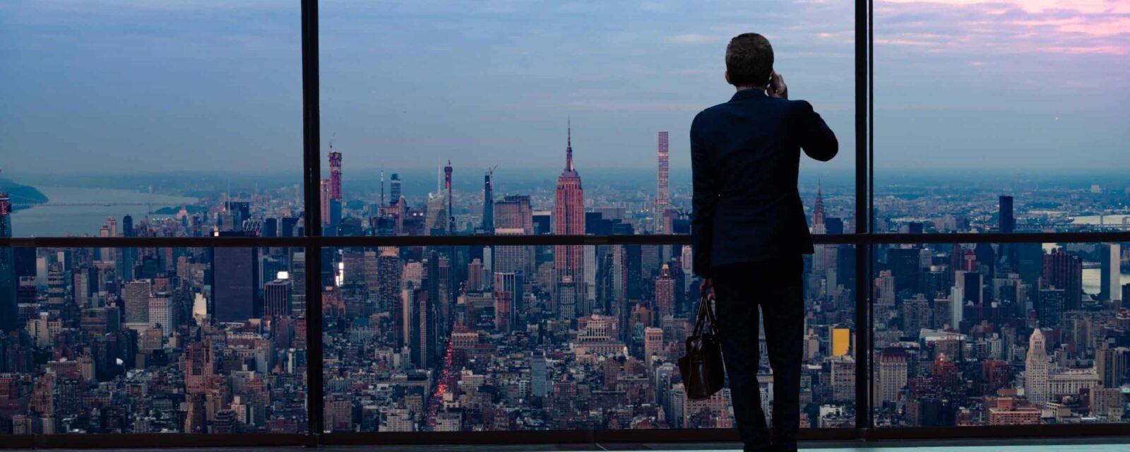 New York mesothelioma lawyer overlooking Manhattan skyline from office window, representing legal expertise for asbestos exposure cases