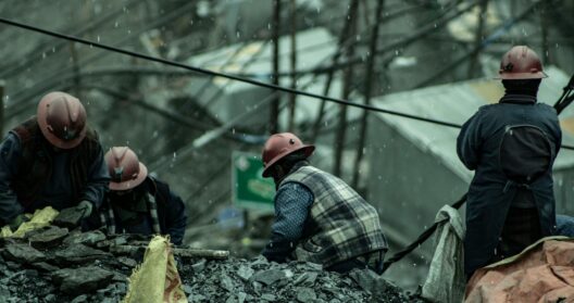 Photograph of demolition workers going through rubble