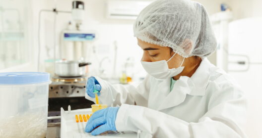 A scientist wearing protective gear performs a meticulous experiment in a laboratory setting