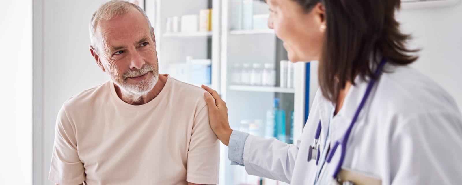 Photograph of female doctor talking with older male patient about stage 1 mesothelioma